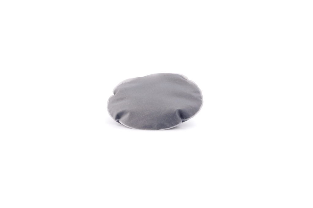 Graues, rundes Kalkfilterpad für Wasserfiltersysteme von Lotus Vita auf weißem Hintergrund.